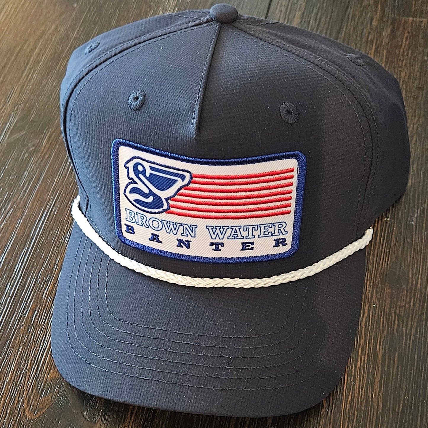 Dark gray cap with a logo and text on a wooden surface